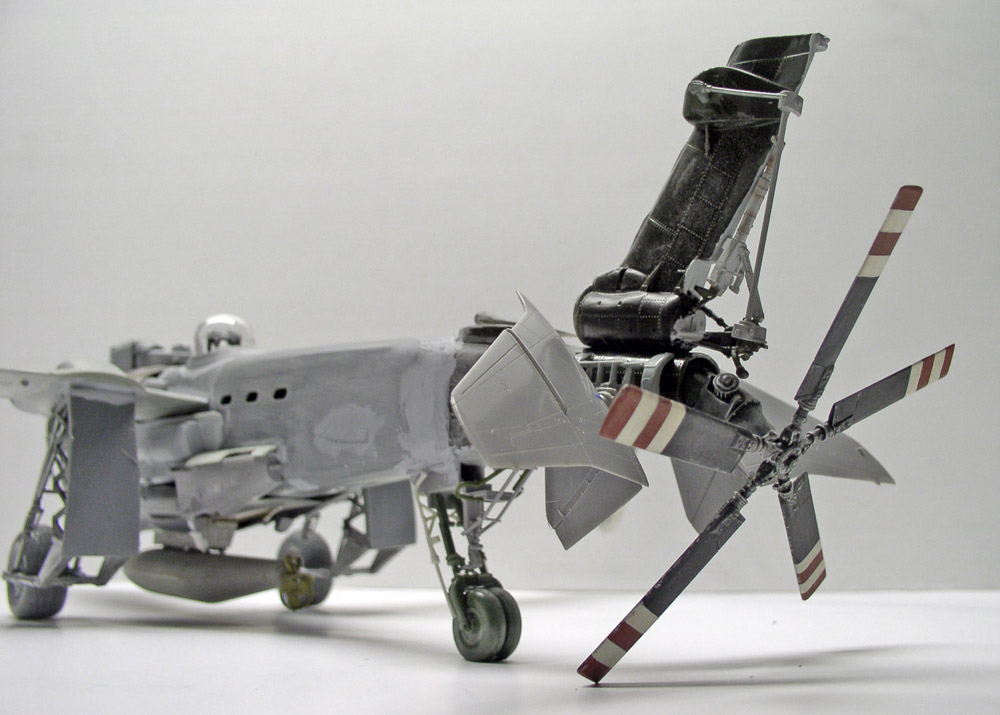 Maquette d'aéronef gris en montage avec siège éjectable relevé et hélice à pales rayées
