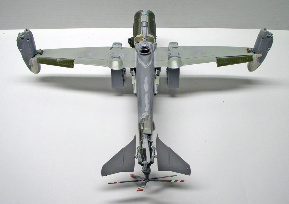 Maquette d'avion bimoteur vue de dessus en cours de peinture grise sur fond blanc