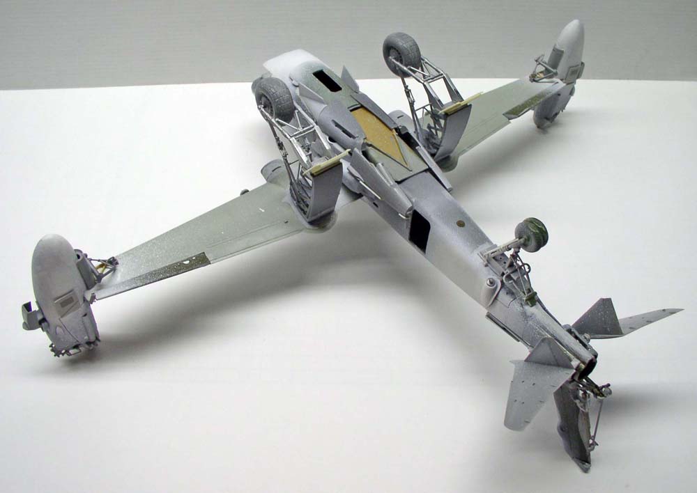 Maquette d'avion bimoteur vue de dessous, train d'atterrissage et baies de roues détaillés, apprêt gris