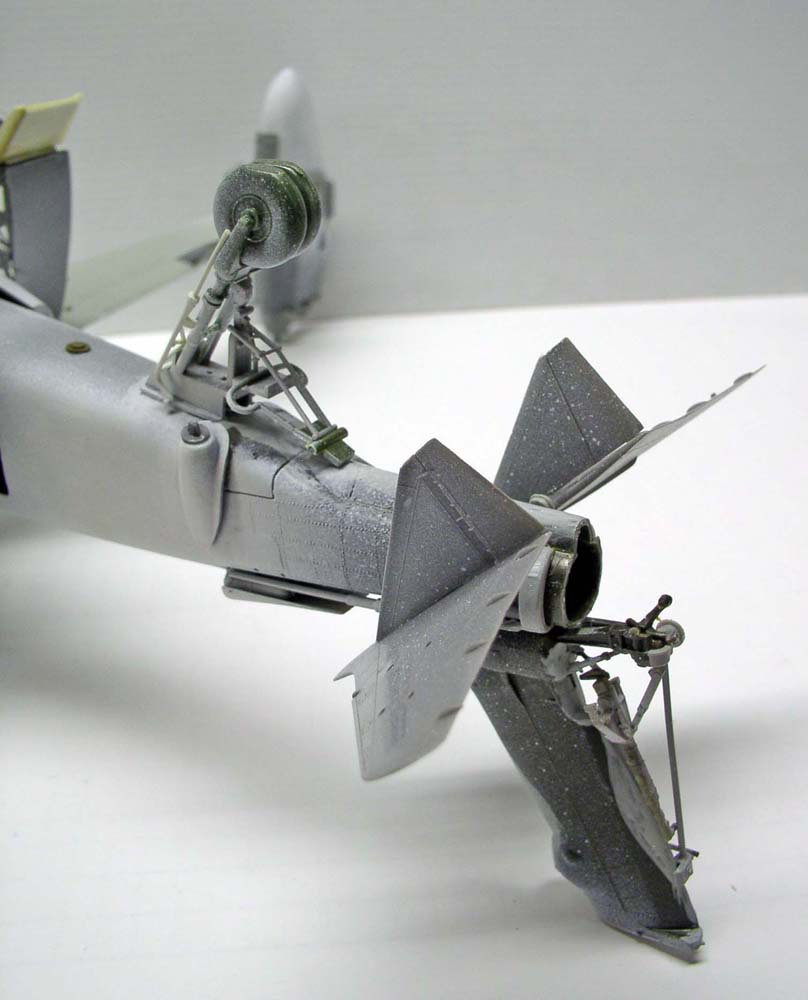 Maquette d'avion en gris apprêt montrant fuselage arrière, empennage et trains d'atterrissage détaillés