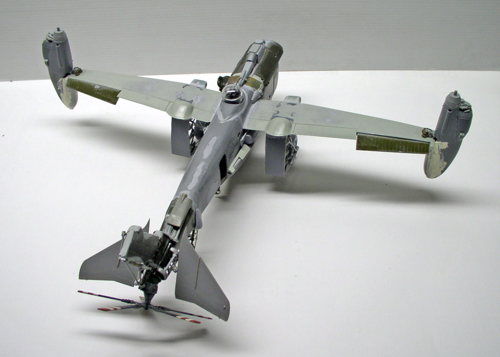 Maquette d'avion bimoteur gris en cours de montage, vue de dessus sur fond blanc