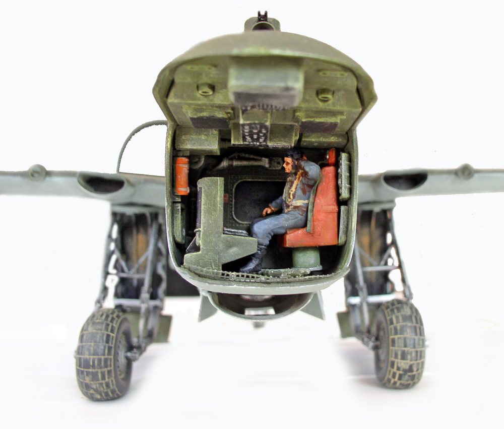 Maquette d'avion militaire vue de face, cockpit ouvert avec figurine de pilote assis