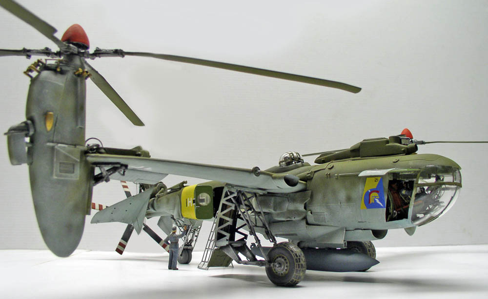 Maquette d'hélicoptère militaire vert avec figurine de mécanicien et échelle de maintenance