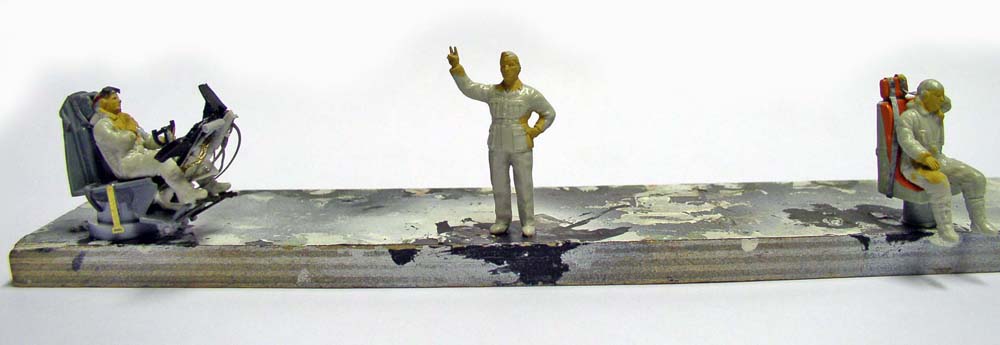 Trois figurines de personnages en cours de peinture sur socle de diorama du Dorthmund III