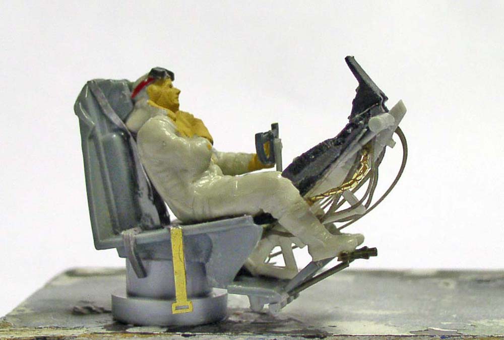 Figurine de pilote assis sur un siège équipé de tuyaux, maquette Dorthmund III en cours de montage