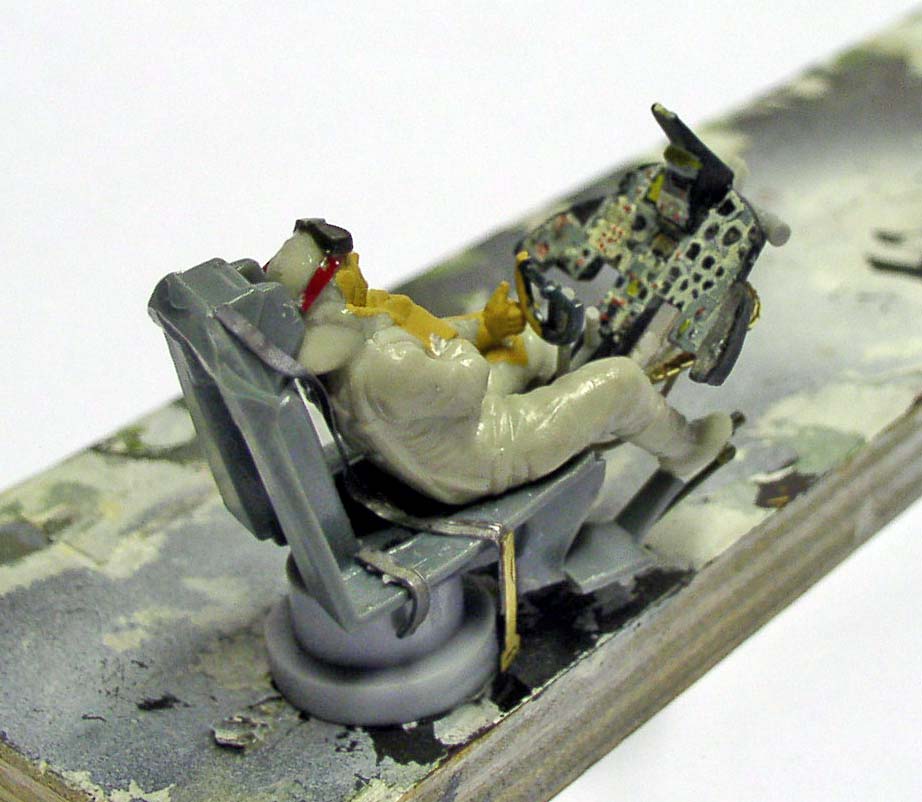 Figurine de pilote assis sur siège éjectable avec tableau de bord en cours de peinture
