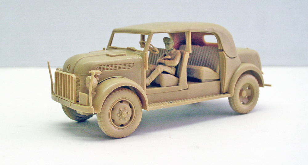 Maquette de voiture militaire ancienne avec figurine de conducteur, montage non peint sur fond clair