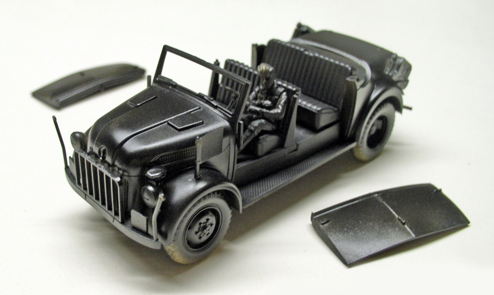 Maquette de voiture militaire décapotable avec figurine de conducteur et portières démontées en cours d'assemblage