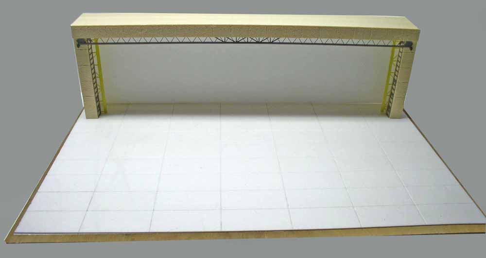 Maquette en construction d'un mur d'enceinte avec poutre treillis et sol carrelé blanc