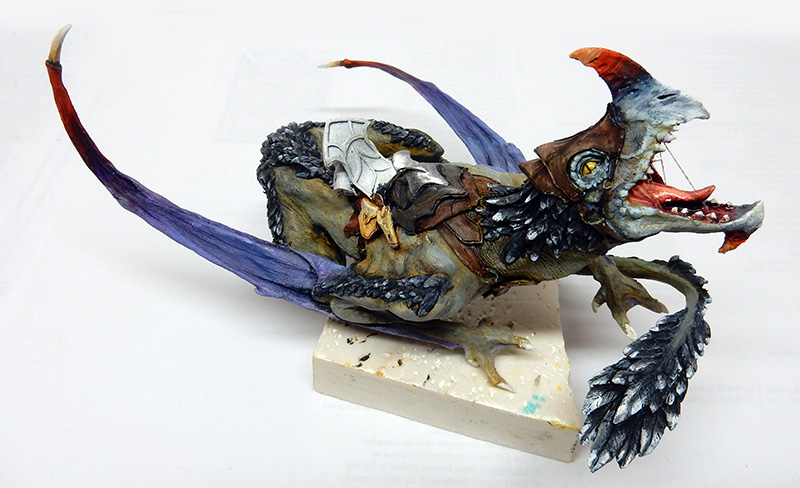 Figurine de dragon ailé peint avec selle, ailes violettes et gueule ouverte sur socle