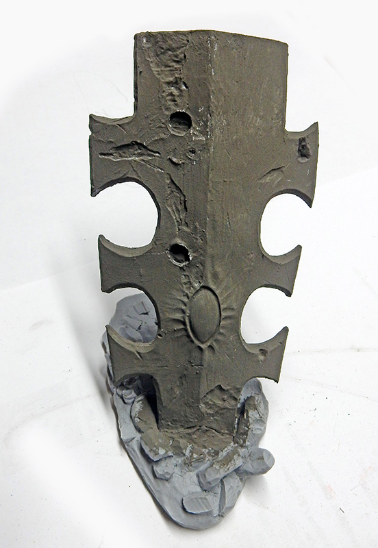 Maquette de stèle gravée en mastic gris posée sur un socle rocheux non peint