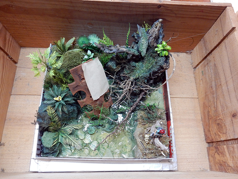 Diorama de maquettisme en construction représentant une jungle luxuriante avec végétation, racines et plan d'eau