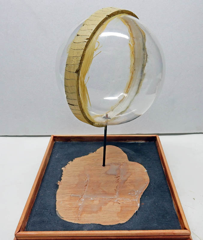 Sphère transparente sur tige fixée à un socle en bois en construction