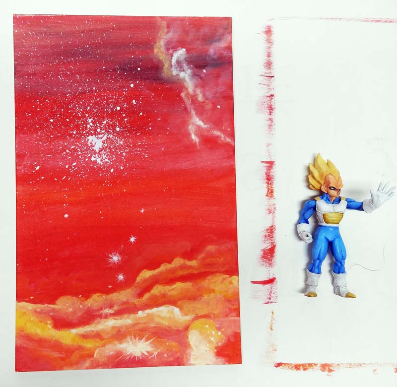 Figurine de Vegeta Super Saiyan à côté d'un décor de ciel rouge peint