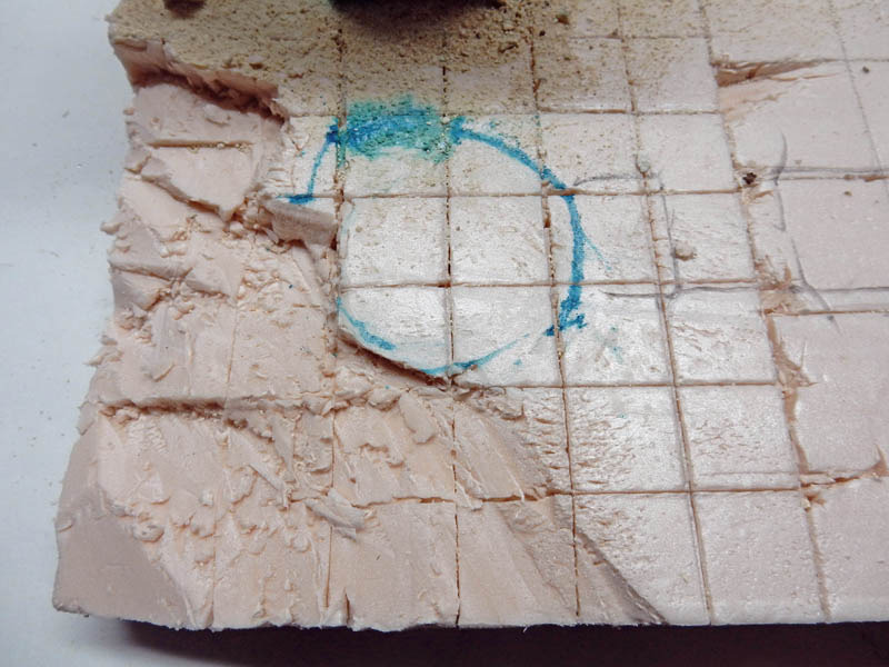 Bloc de mousse rose quadrillé au crayon avec cercle bleu et entaille sculptée