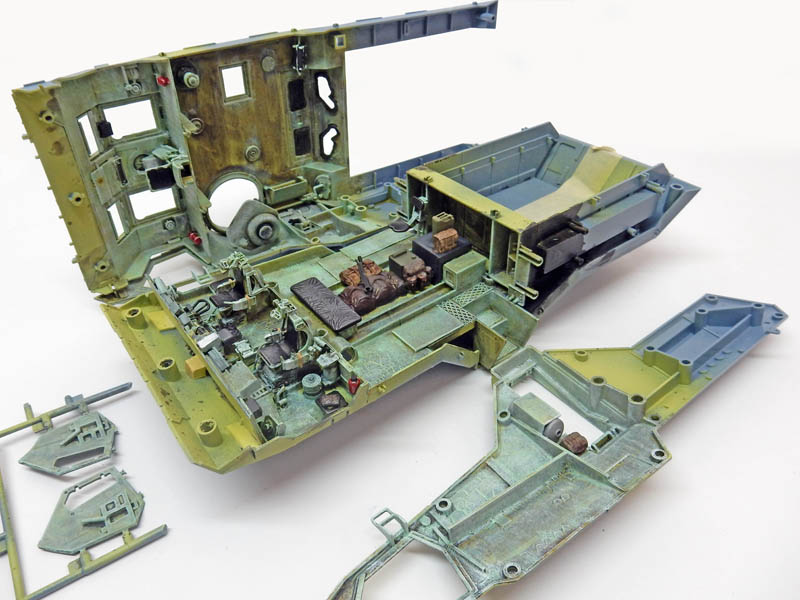 Intérieur peint d'une maquette de véhicule blindé en cours d'assemblage avec compartiment moteur détaillé