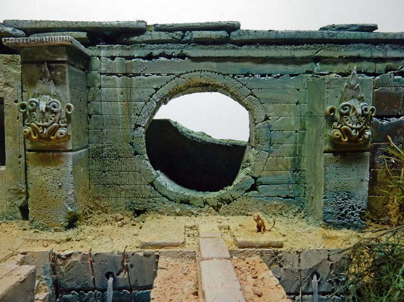 Maquette de muraille en ruine avec ouverture circulaire et petit rat sur le sol