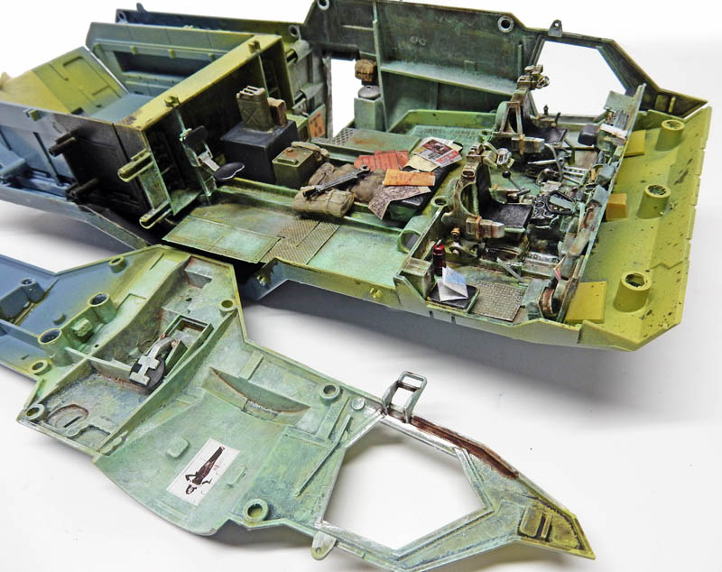 Intérieur détaillé de maquette de véhicule blindé avec compartiment équipé, peinture vieillie vert kaki