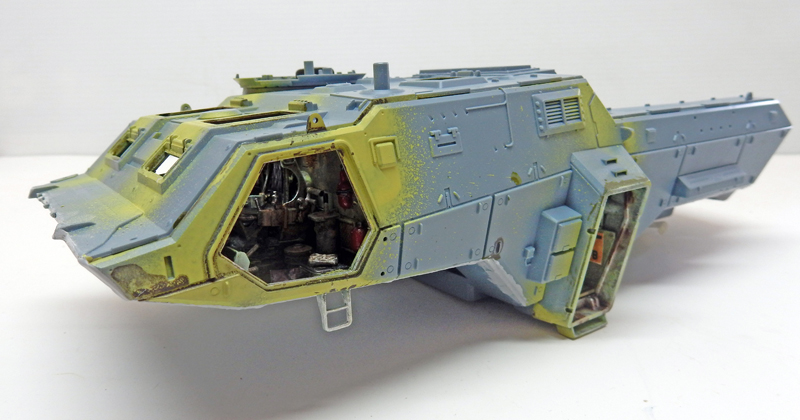 Maquette de véhicule blindé bleu-gris et jaune avec habitacle ouvert et détails intérieurs