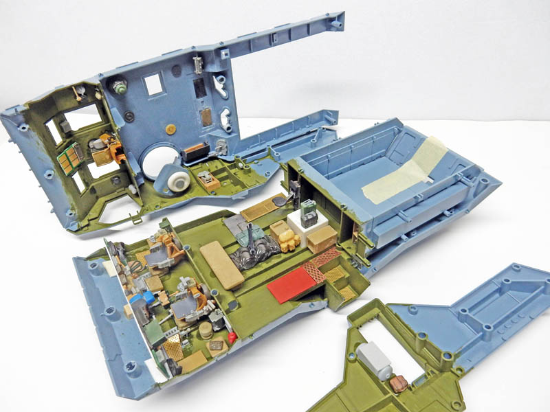 Maquette en montage avec coque bleue et intérieur vert détaillé d'équipements et mobilier miniatures
