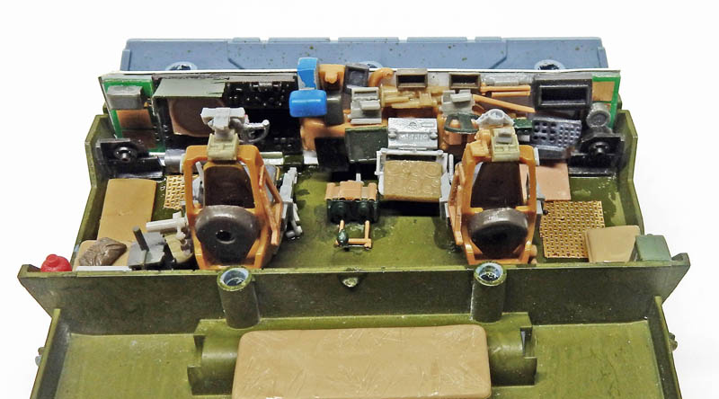 Intérieur de maquette de véhicule militaire avec deux sièges et équipements détaillés en cours de montage