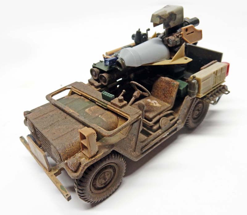 Maquette de jeep militaire équipée d'un missile, finition vieillie poussiéreuse, vue trois quarts avant