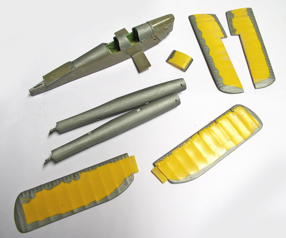Éléments de maquette d'avion peints en gris avec masquage jaune avant assemblage