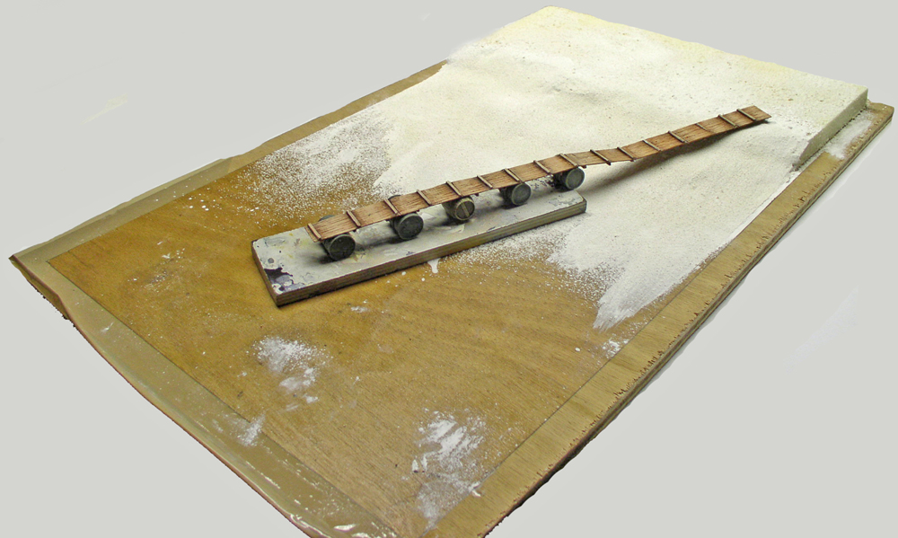 Socle de base en préparation avec passerelle en bois et enduit blanc étalé