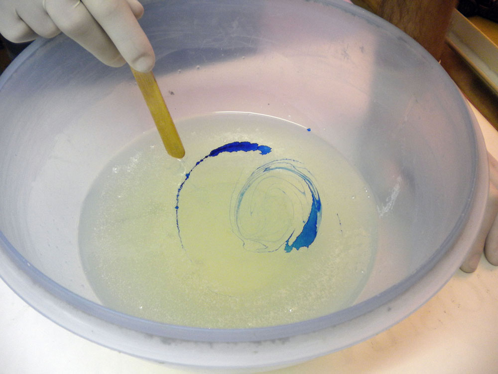 Mélange de pigment bleu dans une résine translucide avec un bâtonnet