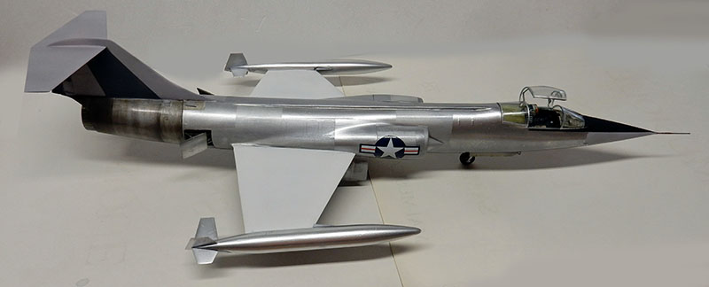 Maquette du F-104 Starfighter terminée en aluminium naturel, vue latérale sur fond neutre