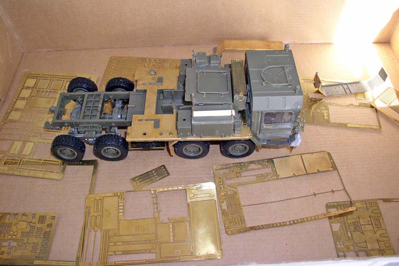 Maquette de camion tracteur militaire gris entourée de grappes de photodécoupe en laiton