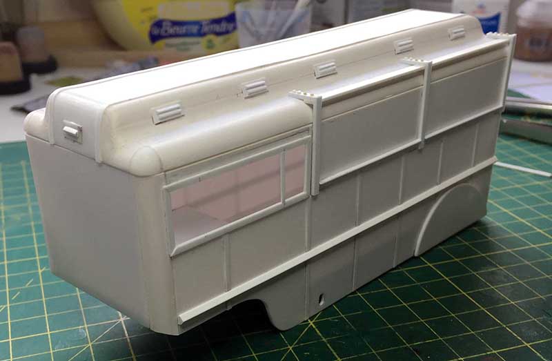 Carrosserie de fourgon en maquette plastique blanche avec fenêtre latérale, posée sur tapis de découpe