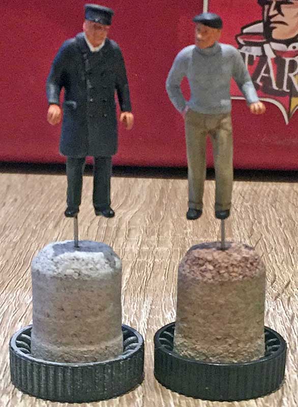 Deux figurines de personnages peintes montées sur des socles pour le séchage