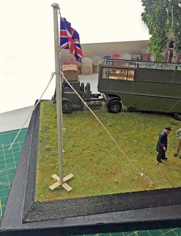 Diorama du Fordson 7V militaire avec mât et drapeau britannique sur socle herbeux