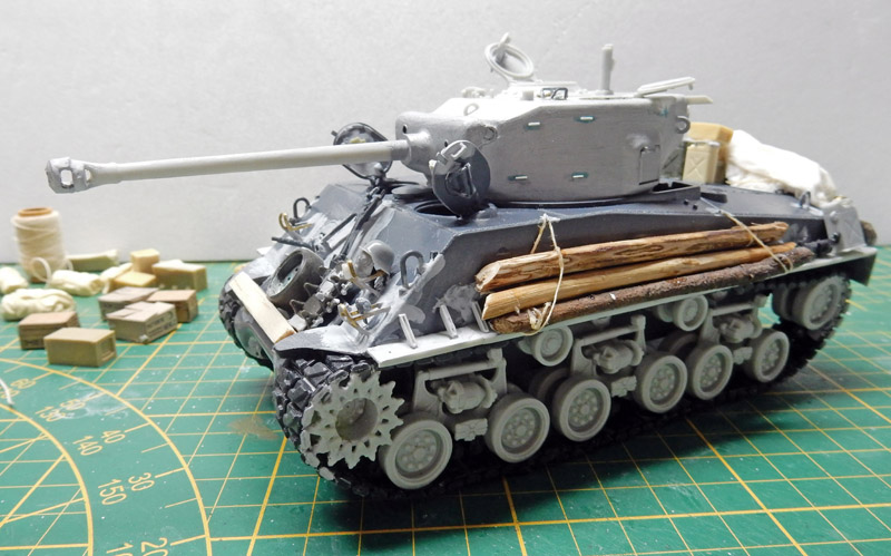 Maquette de char Sherman Fury en cours d'assemblage avec rondins de bois sur tapis de découpe