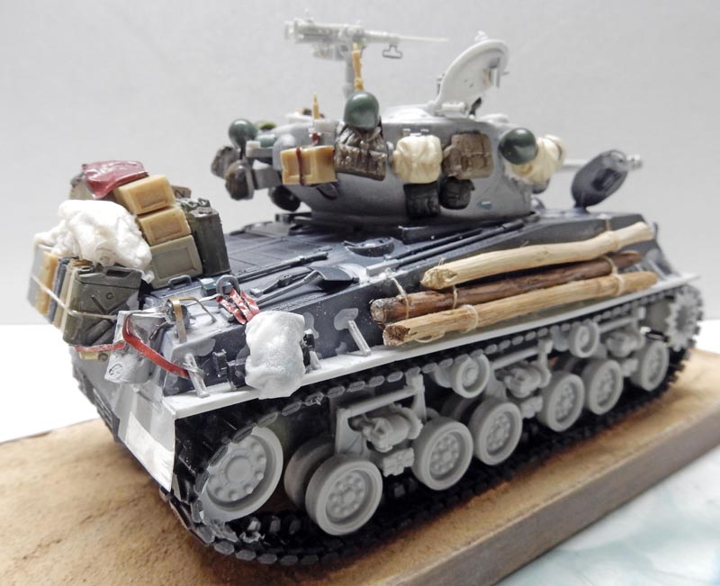 Maquette de char Sherman gris en cours de montage chargé d'équipements, bagages et rondins de bois