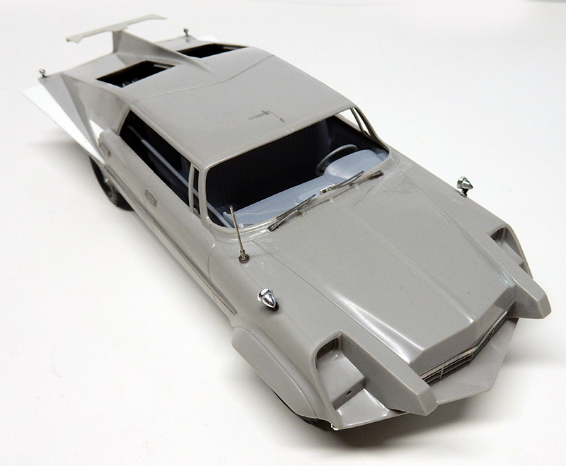 Maquette de voiture grise Future Cop avec aileron arrière et intérieur détaillé en cours de montage