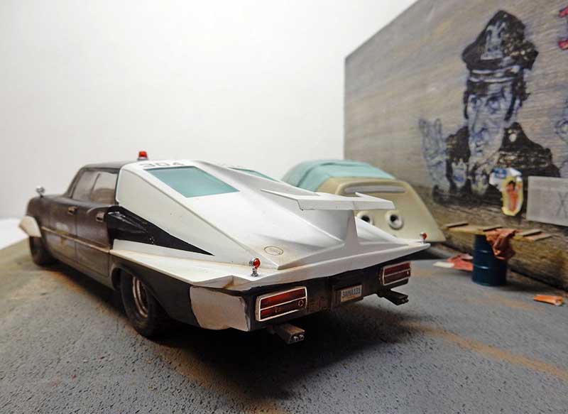 Maquette de voiture de police futuriste vue arrière, carrosserie blanche et noire, diorama urbain