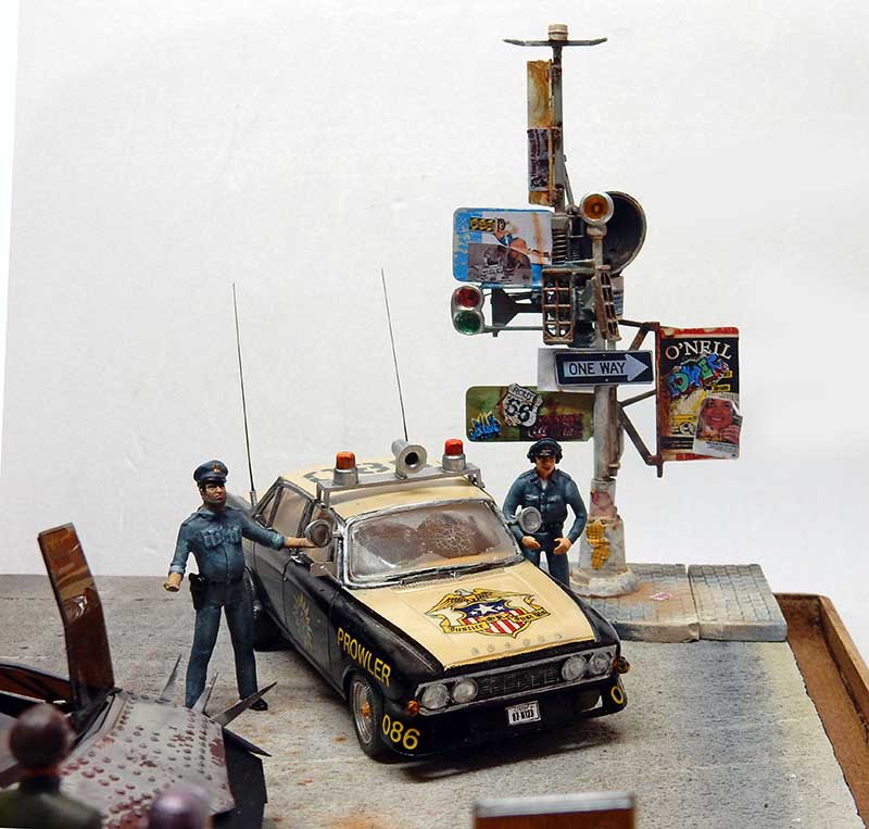 Diorama Future Cop avec voiture de police Prowler, deux figurines de policiers et lampadaire urbain couvert d'affiches