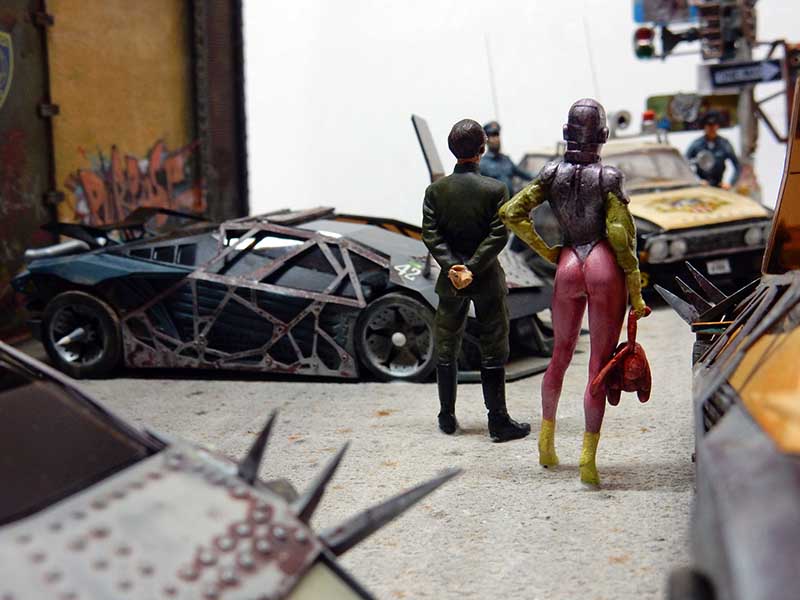 Diorama de maquette avec deux figurines de dos face à des véhicules futuristes blindés