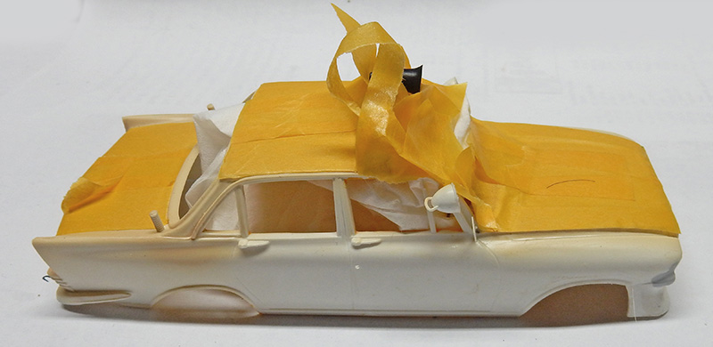 Carrosserie de voiture maquette protégée par du ruban de masquage jaune avant peinture