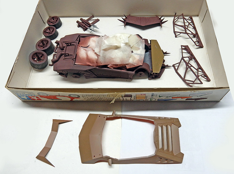 Maquette de voiture Future Cop 01 en cours de montage avec carrosserie masquée et pièces dans la boîte