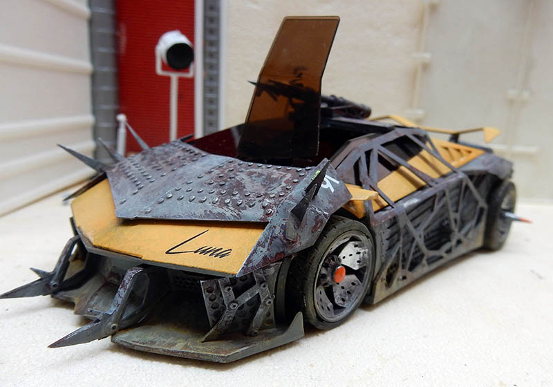 Maquette de voiture futuriste blindée à pointes et plaques rivetées, vitre teintée ouverte vers le haut