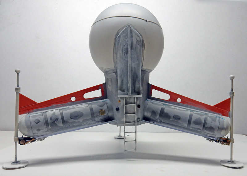 Maquette du vaisseau spatial G.N.U. vue de face, sphère grise, ailes rouges et échelle centrale