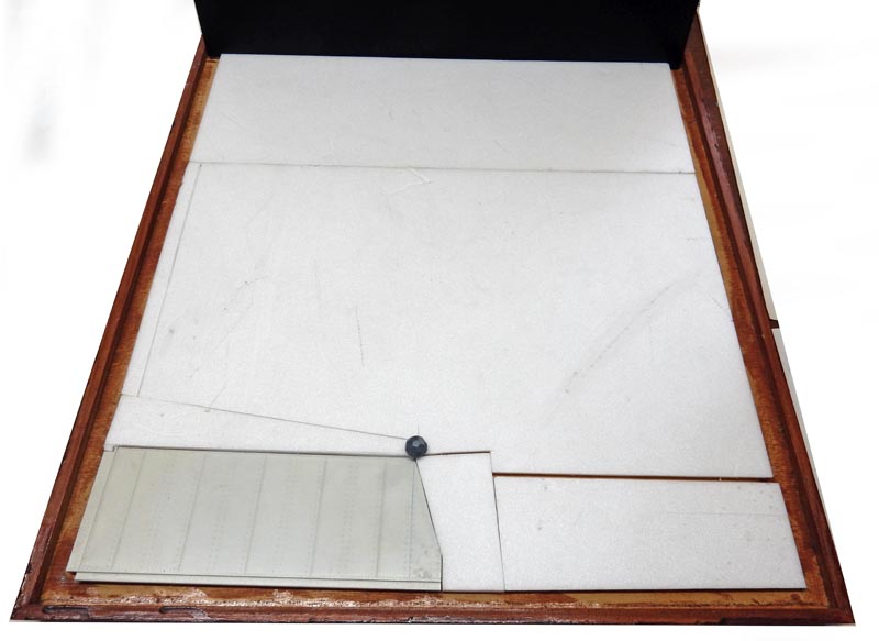 Maquette du G.N.U. en construction sur socle bois, plaques de carton blanc tracées au crayon