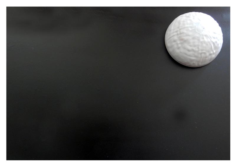 Dôme blanc texturé du G.N.U. posé sur fond noir, en cours de fabrication