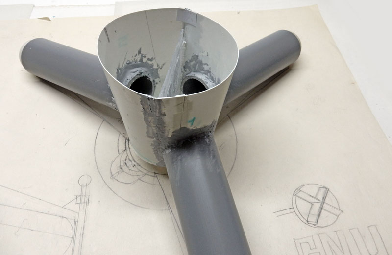 Maquette du G.N.U. en construction, tubes gris assemblés sur un plan dessiné