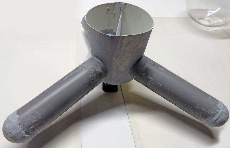 Maquette grise en construction du G.N.U. avec corps cylindrique central et trois bras tubulaires