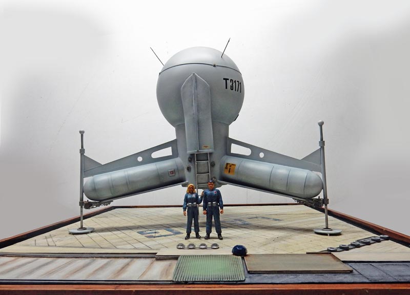 Maquette du vaisseau spatial G.N.U. immatriculé T3171 avec deux figurines de pionniers devant