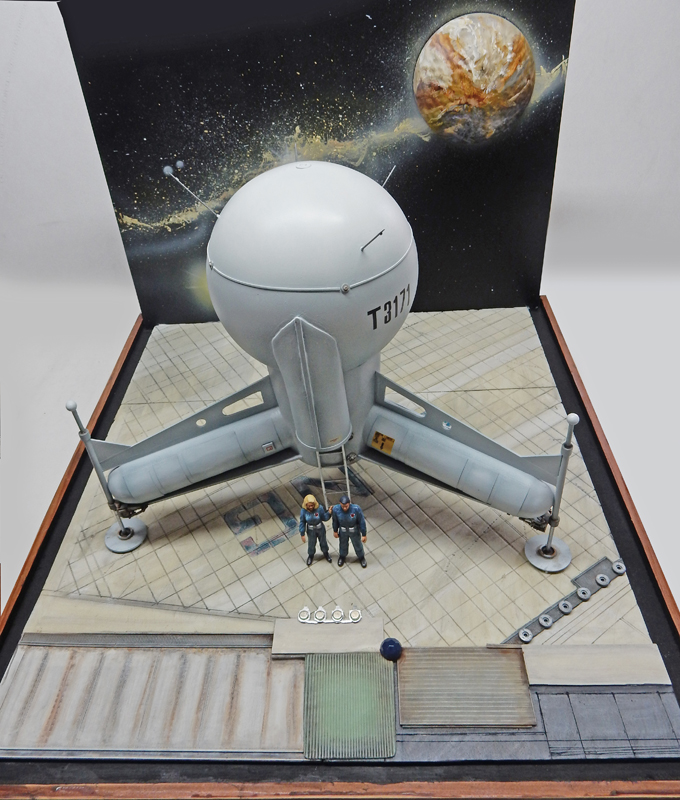 Maquette du vaisseau sphérique G.N.U. T 3171 sur diorama spatial avec deux astronautes et planète